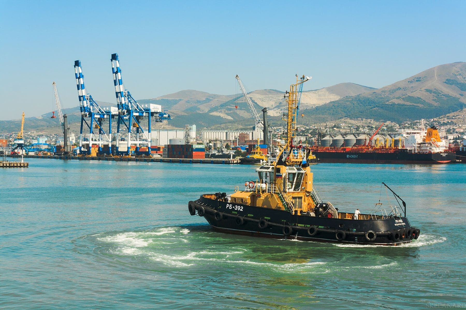 Harbour cranes and a tug boat at a sea port